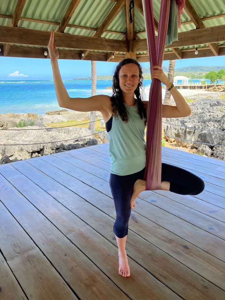 Kelsey standing on ground in aerial tree pose