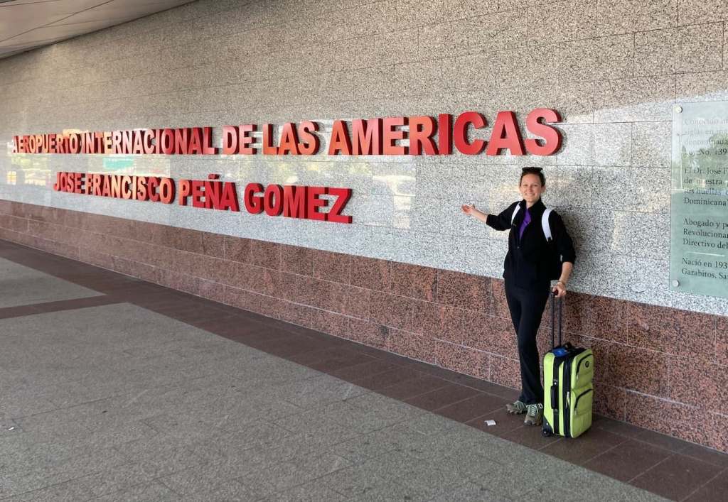Kelsey standing with suitcase outside Santo Domingo airport