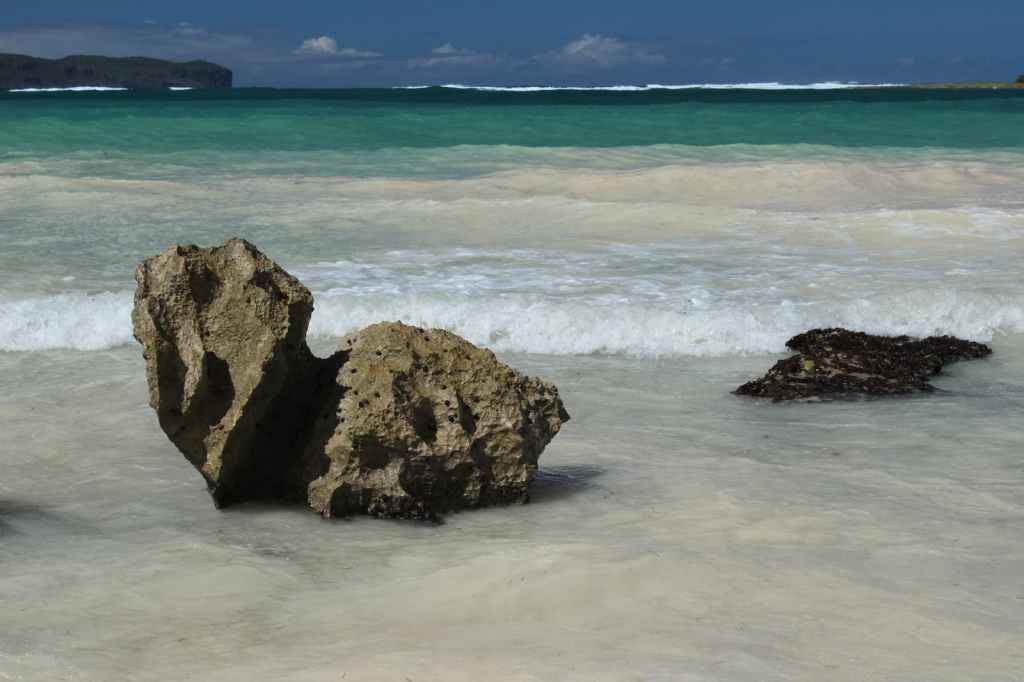 Rocks on ocean beach with waves washing in